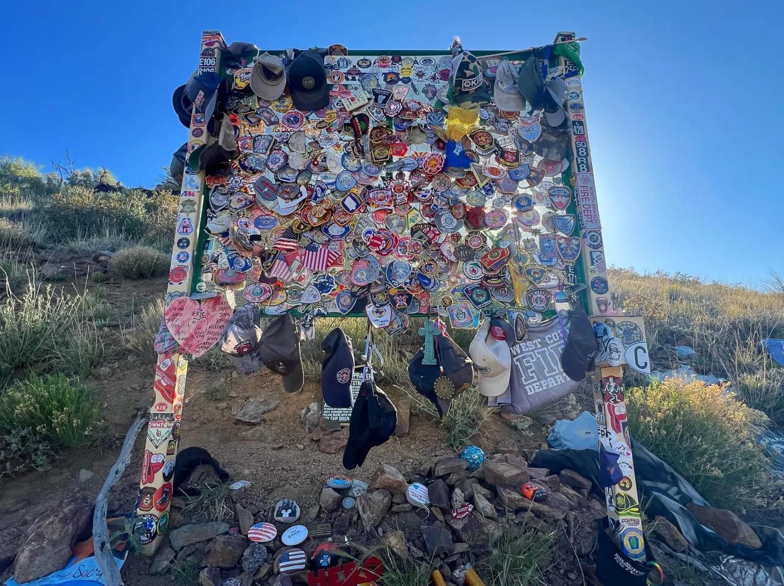 Trailside tribute frame covered with patches and memorial items at Granite Mountain Hotshots Memorial State Park near Yarnell, Arizona