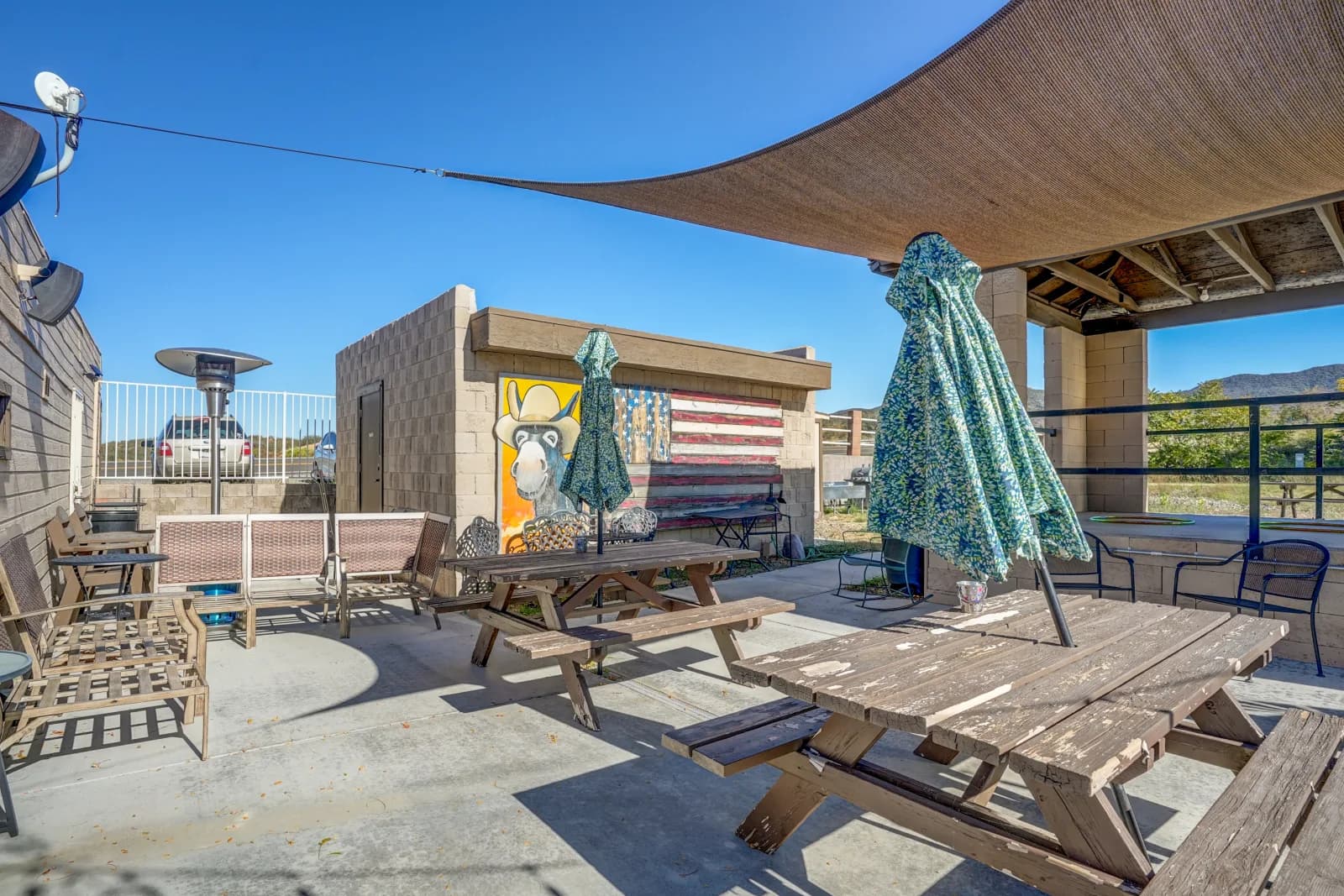 Back patio seating with umbrellas and colorful wall murals